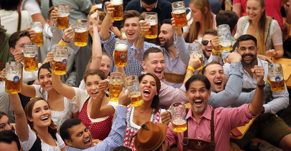 Revelers cheer with 1-liter-mugs of beer during the opening weekend of the Oktoberfest 